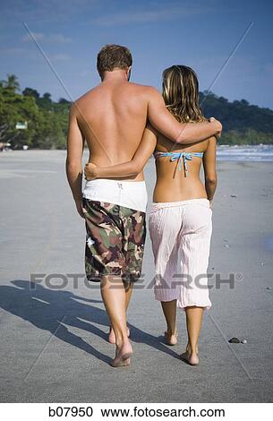 Romantic couple strolling on the beach View Large Photo Image Stock Image - Romantic couple strolling on the beach. Fotosearch
