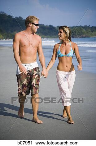 Romantic couple strolling on the beach View Large Photo Image Stock Image - Romantic couple strolling on the beach. Fotosearch