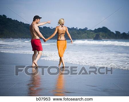 Romantic couple strolling on the beach View Large Photo Image Stock Image - Romantic couple strolling on the beach. Fotosearch