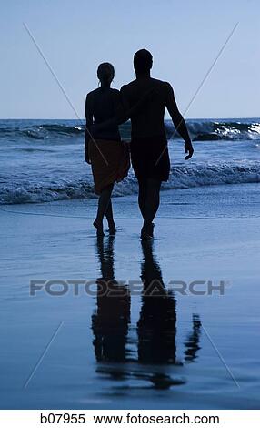 Stock Photography - Romantic couple strolling on the beach. Fotosearch