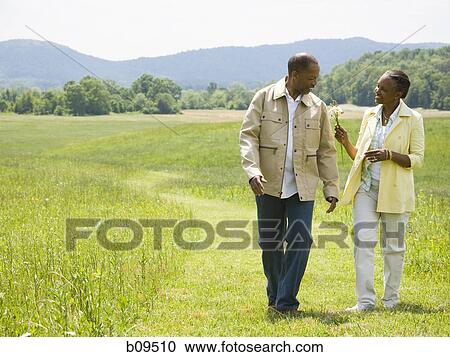 Senior man and a senior woman walking in a field View Large Photo Image Stock Image - Senior man and a senior woman walking in a field. Fotosearch