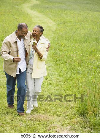 Senior man and a senior woman walking in a field View Large Photo Image Stock Image - Senior man and a senior woman walking in a field. Fotosearch