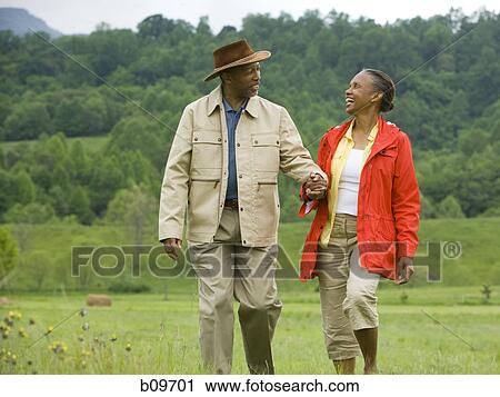 Senior man and a senior woman walking in a field View Large Photo Image Stock Image - Senior man and a senior woman walking in a field. Fotosearch