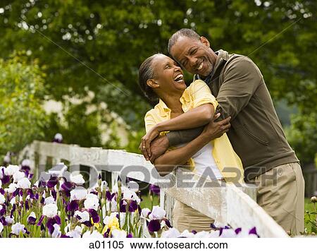 Stock Photography - Senior man embracing a senior woman from behind. Fotosearch