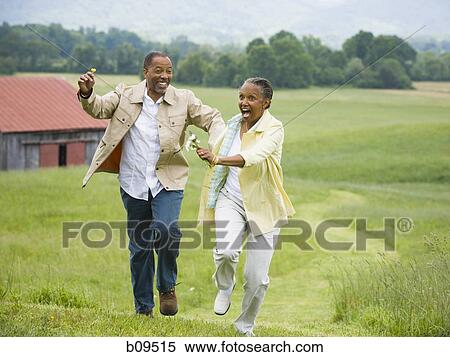 Senior woman and a senior man running in a field View Large Photo Image Stock Photography - Senior woman and a senior man running in a field. Fotosearch