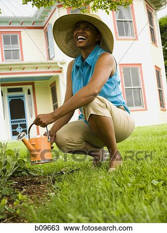 Senior woman watering plants View Large Photo Image Stock Image - Senior woman watering plants. Fotosearch