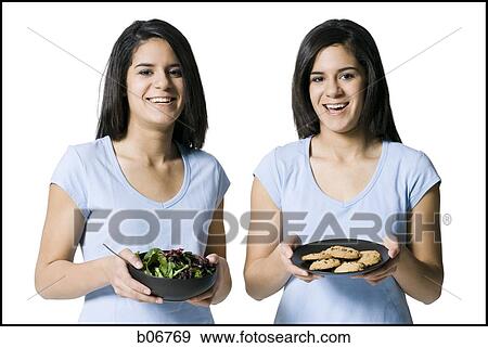 Sisters offering salad and cookies View Large Photo Image Stock Photo - Sisters offering salad and cookies. Fotosearch