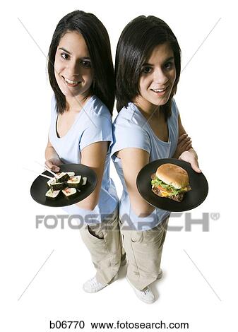 Sisters offering sushi and hamburger View Large Photo Image Stock Image - Sisters offering sushi and hamburger. Fotosearch