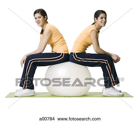Sisters sitting on yoga ball View Large Photo Image Picture - Sisters sitting on yoga ball. Fotosearch