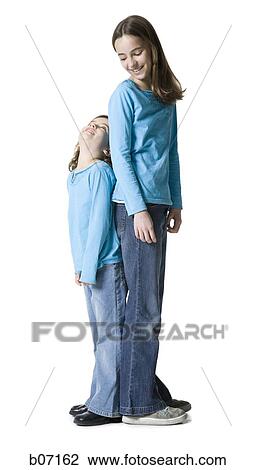 Sisters standing back to back View Large Photo Image Stock Image - Sisters standing back to back. Fotosearch