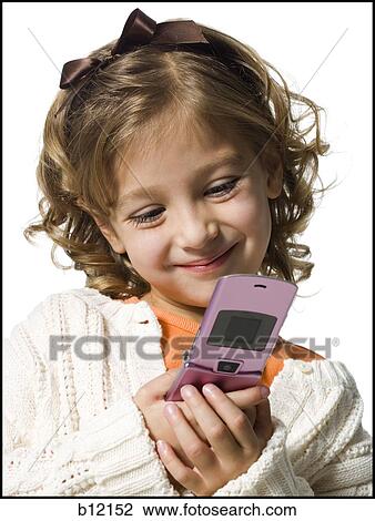 Stock Image - Smiling young girl in white sweater with cell phone. Fotosearch