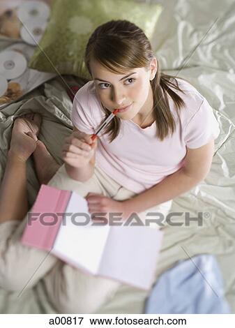 Teenage girl contemplating with notebook and pen View Large Photo Image Stock Photo - Teenage girl contemplating with notebook and pen. Fotosearch