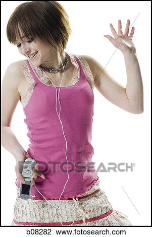 Teenage girl holding a mobile phone and listening to music View Large Photo Image Stock Image - Teenage girl holding a mobile phone and listening to music. Fotosearch