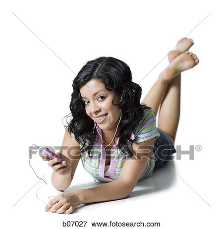 Teenage girl lying down with listening device View Large Photo Image Stock Photo - Teenage girl lying down with listening device. Fotosearch