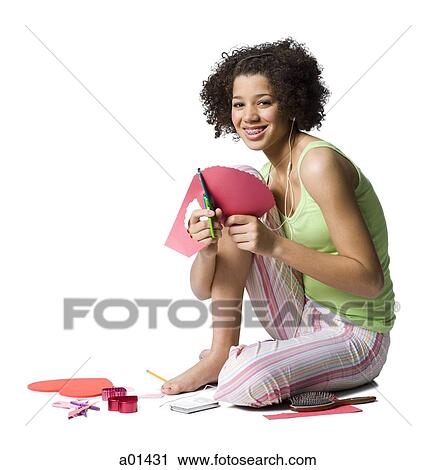 Teenage girl with braces and ear buds cutting out hearts with scissors View Large Photo Image Stock Image - Teenage girl with braces and ear buds cutting out hearts with scissors. Fotosearch
