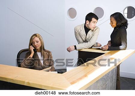 Stock Photo - Three office workers in reception area. Fotosearch