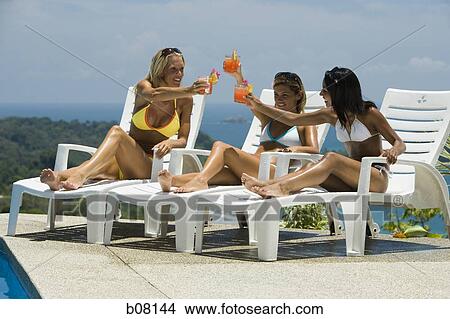 Three women relaxing on deck loungers View Large Photo Image Picture - Three women relaxing on deck loungers. Fotosearch