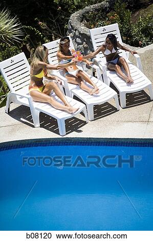 Three women relaxing on deck loungers View Large Photo Image Stock Image - Three women relaxing on deck loungers. Fotosearch