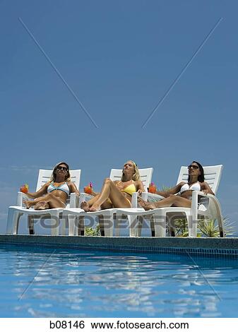 Three women relaxing on deck loungers View Large Photo Image Stock Photograph - Three women relaxing on deck loungers. Fotosearch