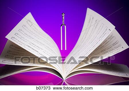 Tuning fork hovering over musical score View Large Photo Image Stock Image - Tuning fork hovering over musical score. Fotosearch
