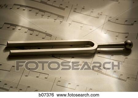 Tuning fork resting on musical score View Large Photo Image Stock Photograph - Tuning fork resting on musical score. Fotosearch