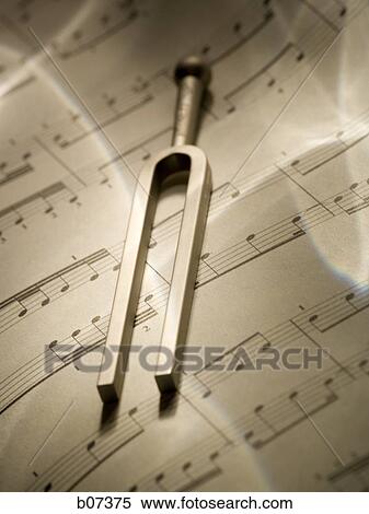 Tuning fork resting on musical score View Large Photo Image Stock Photography - Tuning fork resting on musical score. Fotosearch