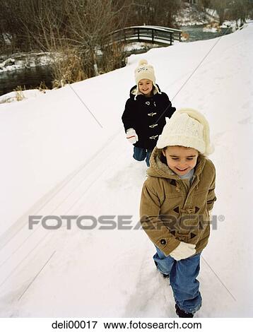 Two boys walking in snow View Large Photo Image Stock Photo - Two boys walking in snow. Fotosearch