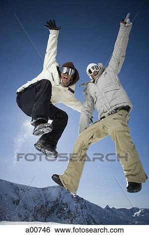 Two friends jumping outside in the snow View Large Photo Image Stock Photograph - Two friends jumping outside in the snow. Fotosearch