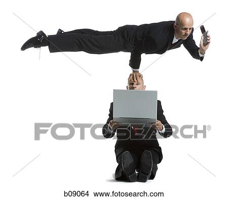 Two male acrobats in business suits performing View Large Photo Image Picture - Two male acrobats in business suits performing. Fotosearch