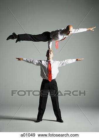 Stock Photo - Two male acrobats in business suits. Fotosearch