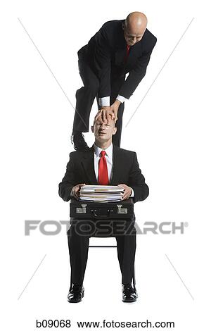 Stock Photo - Two male acrobats in business suits performing. Fotosearch