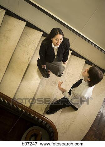 Two people chatting on stairway View Large Photo Image Stock Photo - Two people chatting on stairway. Fotosearch