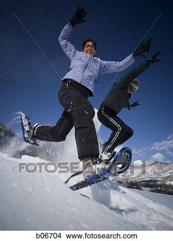 Two people jumping with snow shoes View Large Photo Image Picture - Two people jumping with snow shoes. Fotosearch