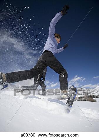 Two people jumping with snow shoes View Large Photo Image Stock Image - Two people jumping with snow shoes. Fotosearch