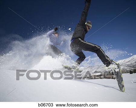Two people jumping with snow shoes View Large Photo Image Stock Image - Two people jumping with snow shoes. Fotosearch