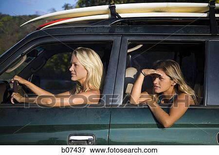 Two women surfers driving to the beach View Large Photo Image Stock Photo - Two women surfers driving to the beach. Fotosearch