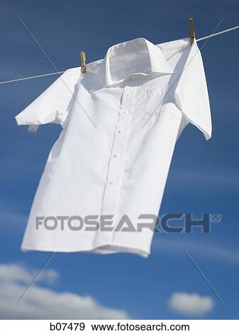 White cotton shirt hanging on a clothesline View Large Photo Image Stock Photo - White cotton shirt hanging on a clothesline. Fotosearch