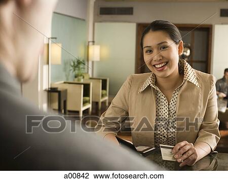 Woman accepting payment at check in counter View Large Photo Image Stock Image - Woman accepting payment at check in counter. Fotosearch