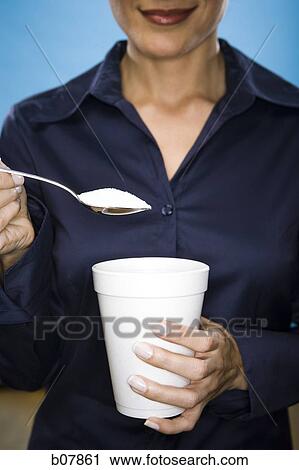 Woman adding sugar to her beverage View Large Photo Image Stock Image - Woman adding sugar to her beverage. Fotosearch