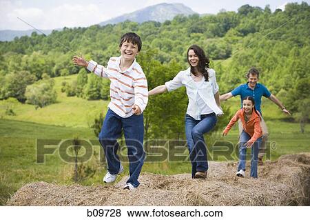 woman and a man standing with their children on hay bales View Large Photo Image Stock Photo - woman and a man standing with their children on hay bales. Fotosearch