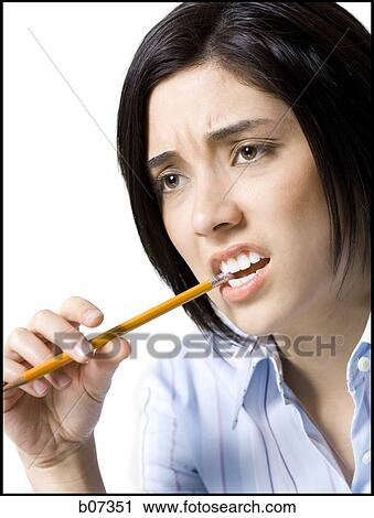 Woman biting pencil View Large Photo Image Stock Image - Woman biting pencil. Fotosearch
