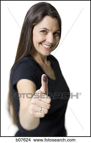 Woman displaying thumb with ink stain View Large Photo Image Picture - Woman displaying thumb with ink stain. Fotosearch