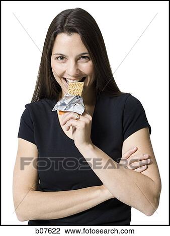 Woman eating a snack bar View Large Photo Image Stock Image - Woman eating a snack bar. Fotosearch