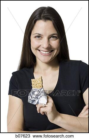 Woman eating a snack bar View Large Photo Image Stock Image - Woman eating a snack bar. Fotosearch