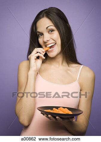 Woman eating carrot sticks View Large Photo Image Stock Image - Woman eating carrot sticks. Fotosearch