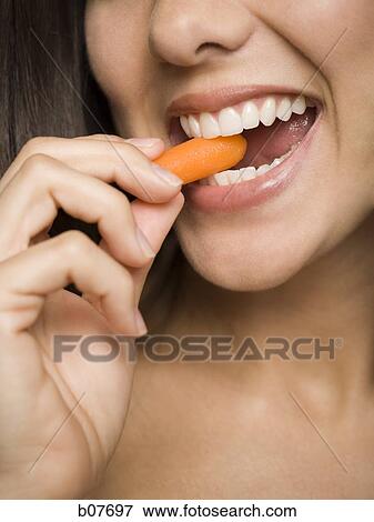 Woman eating carrot sticks View Large Photo Image Stock Photo - Woman eating carrot sticks. Fotosearch