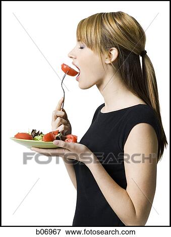 Woman eating healthy plate of food View Large Photo Image Stock Photo - Woman eating healthy plate of food. Fotosearch