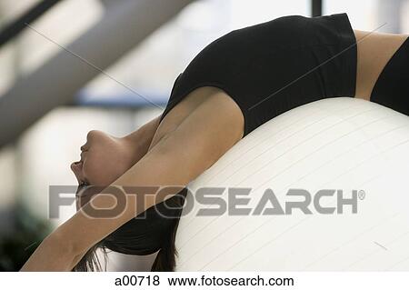Stock Photo - Woman exercising with a pilates ball. Fotosearch