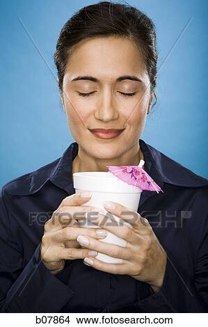 Woman holding a beverage with pink umbrella decoration View Large Photo Image Picture - Woman holding a beverage with pink umbrella decoration. Fotosearch