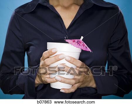 Woman holding a beverage with pink umbrella decoration View Large Photo Image Stock Image - Woman holding a beverage with pink umbrella decoration. Fotosearch